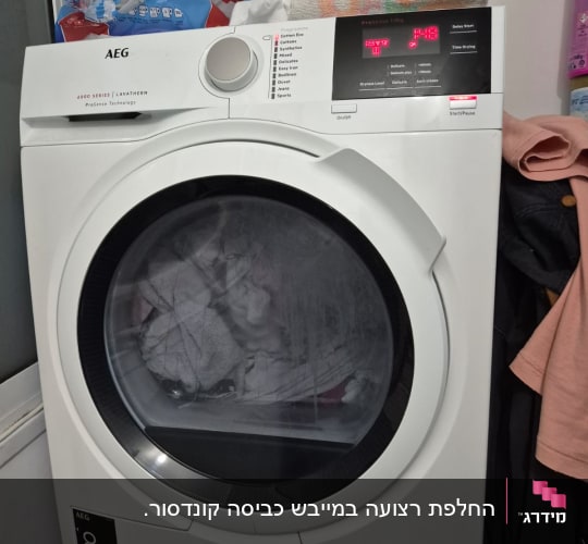 מייבש כביסה AEG עם בגדים בפנים